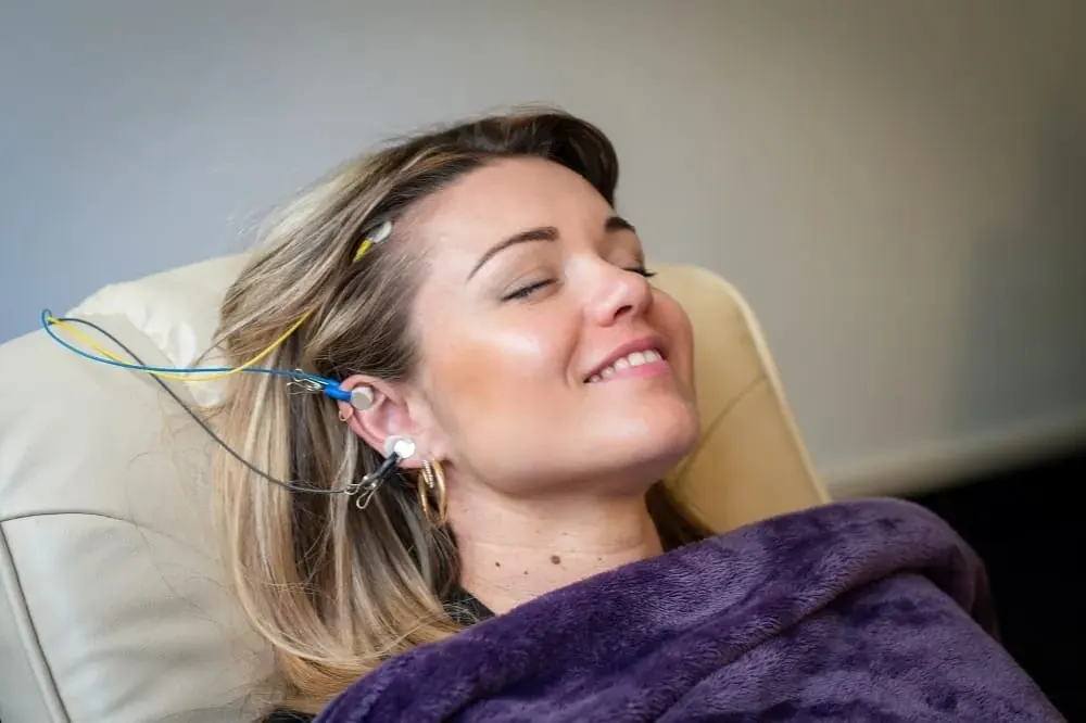 Patiente souriante lors d'une séance de neurofeedback